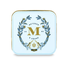 Load image into Gallery viewer, Petit Metzger signature tin in pastel blue filled with 4 different Lebkuchen 'honey cake' pralines: almond, orange marzipan, nut rum and aranzini.