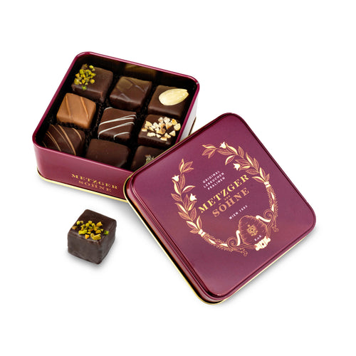 A perfect gift for a special occasion. Metzger's signature luxury tin in opulent red, filled with with 9 delectable Lebkuchen chocolate pralines. Each praline is layered with Lebkuchen 'honey cake' and filled with marzipan, nuts or fruit jams and jellies, encased in rich chocolate. Suitable for vegetarians.