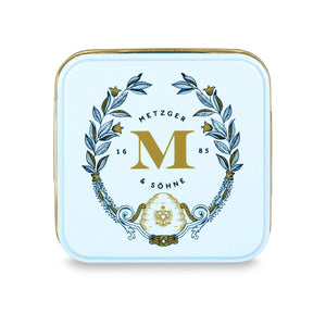 Petit Metzger signature tin in pastel blue filled with 4 different Lebkuchen 'honey cake' pralines: almond, orange marzipan, nut rum and aranzini.
