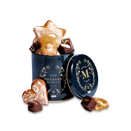 Luxury Metzger gift tin in navy blue, filled with our popular Lebkuchen cookies and chocolate pralines. There are 10 opulent praline types, from marzipan mixes to fruit jellies, jams and nut fillings, coated in chocolate. The Lebkuchen cookies include our fruit bread with dried fruits and nuts, basler with a cherry undertone, chocolate robbins, signature house Lebkuchen and Aranzini Lebkuchen minis. A perfect Lebkuchen taster gift or selection for the Christmas table.